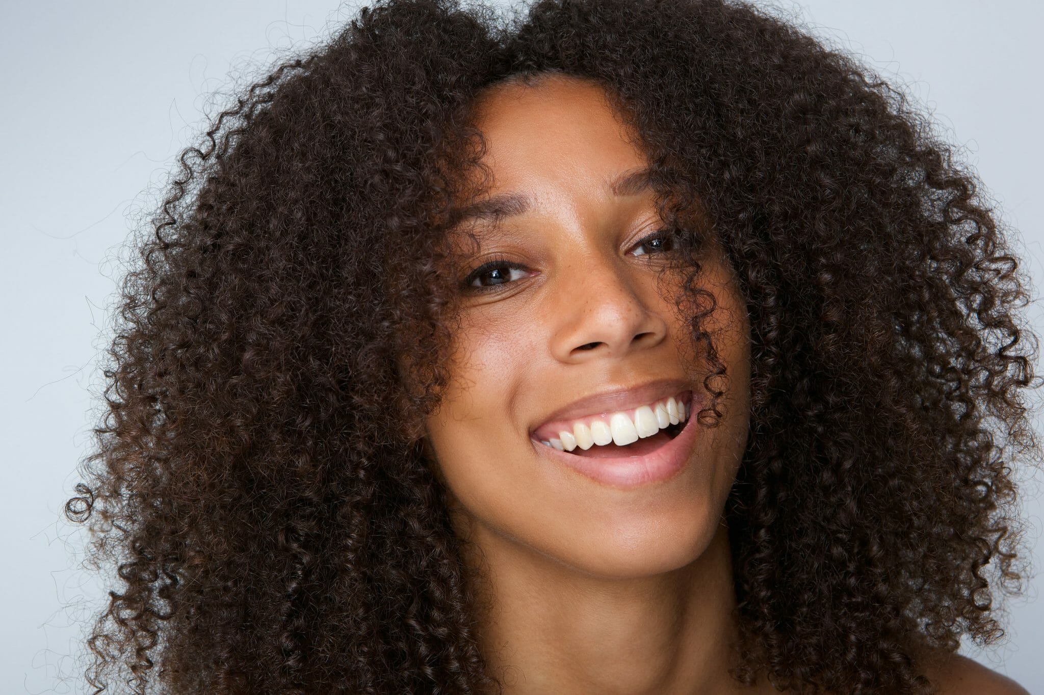 Happy african american woman with curly hair laughing