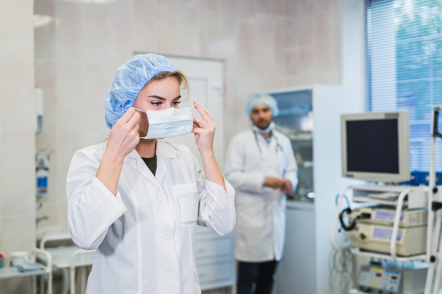 Confident female doctor putting on medical face mask