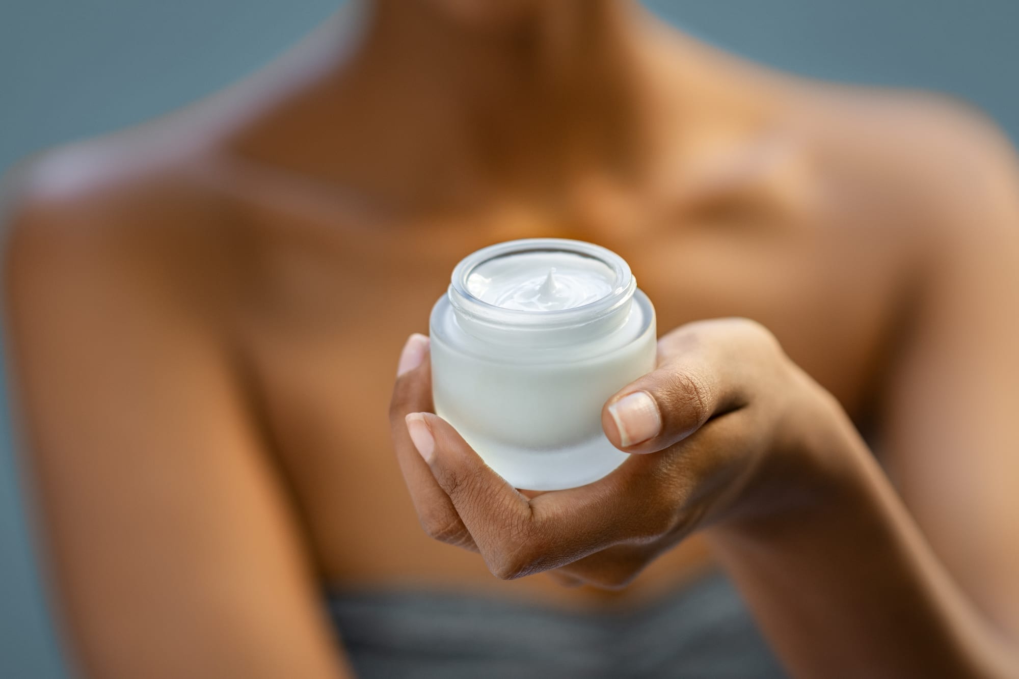 woman holding a bottle of beauty moisturizer