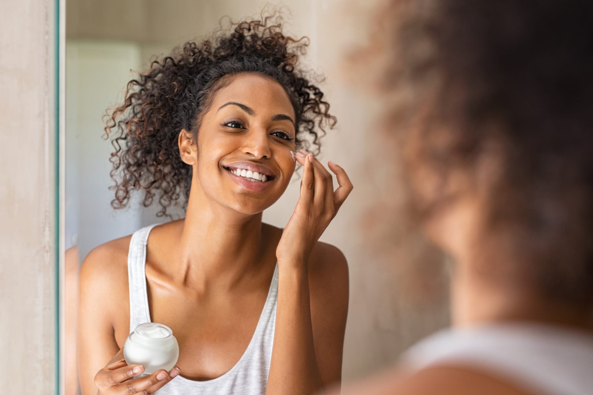 woman applying moisturizer to her face