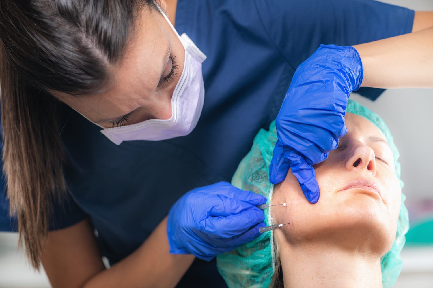 woman receiving a face injection from a doctor