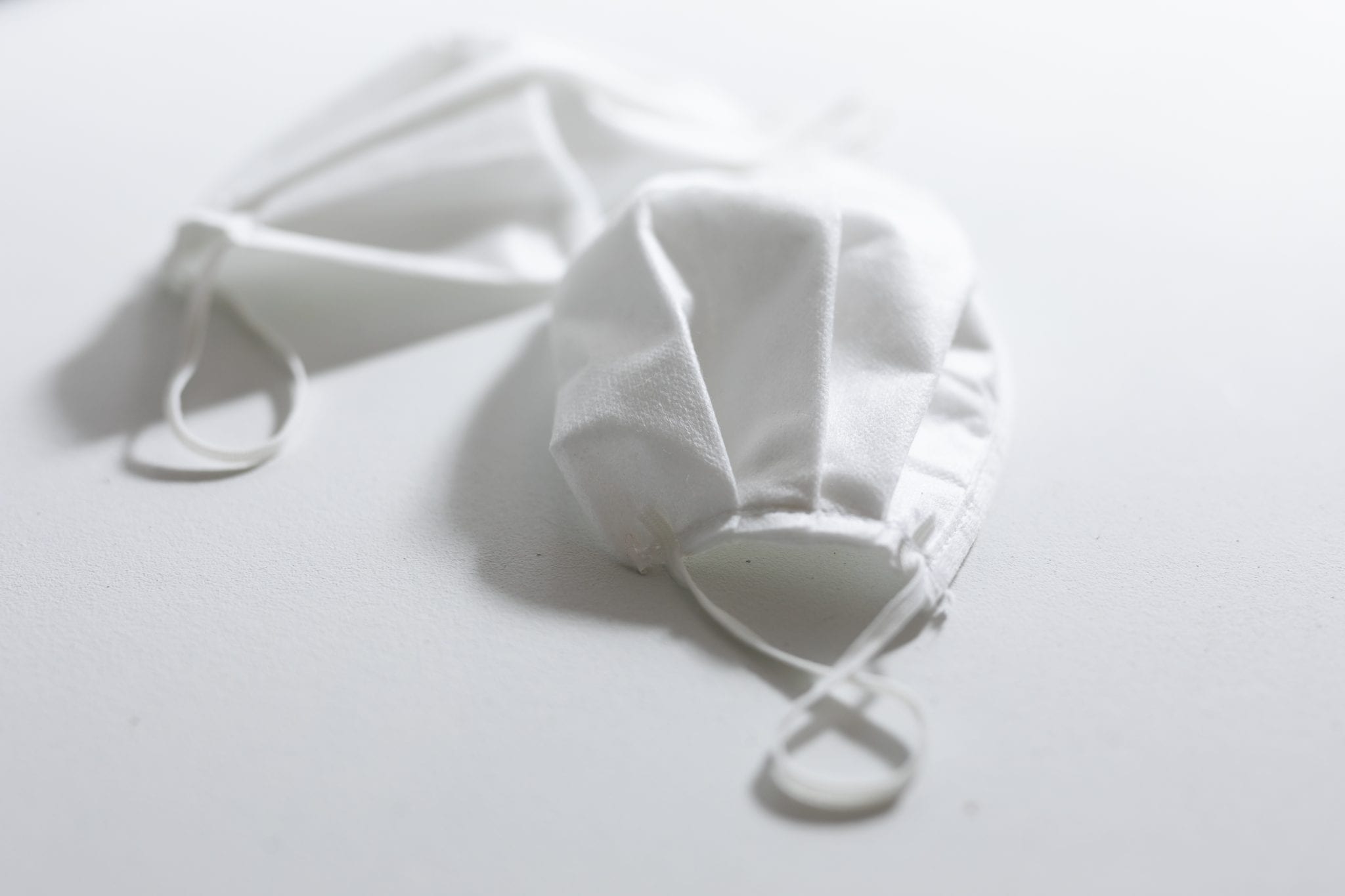 white surgical face mask on a white background