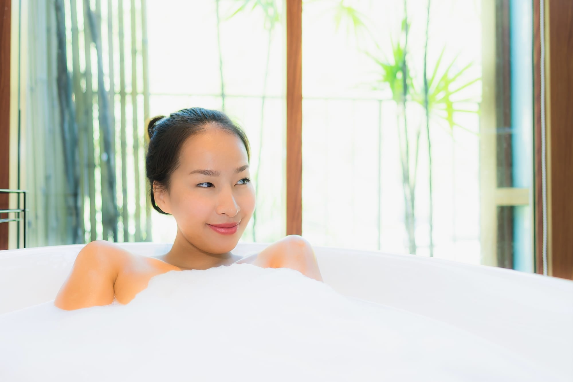 beautiful young woman relaxing in spa bathtub