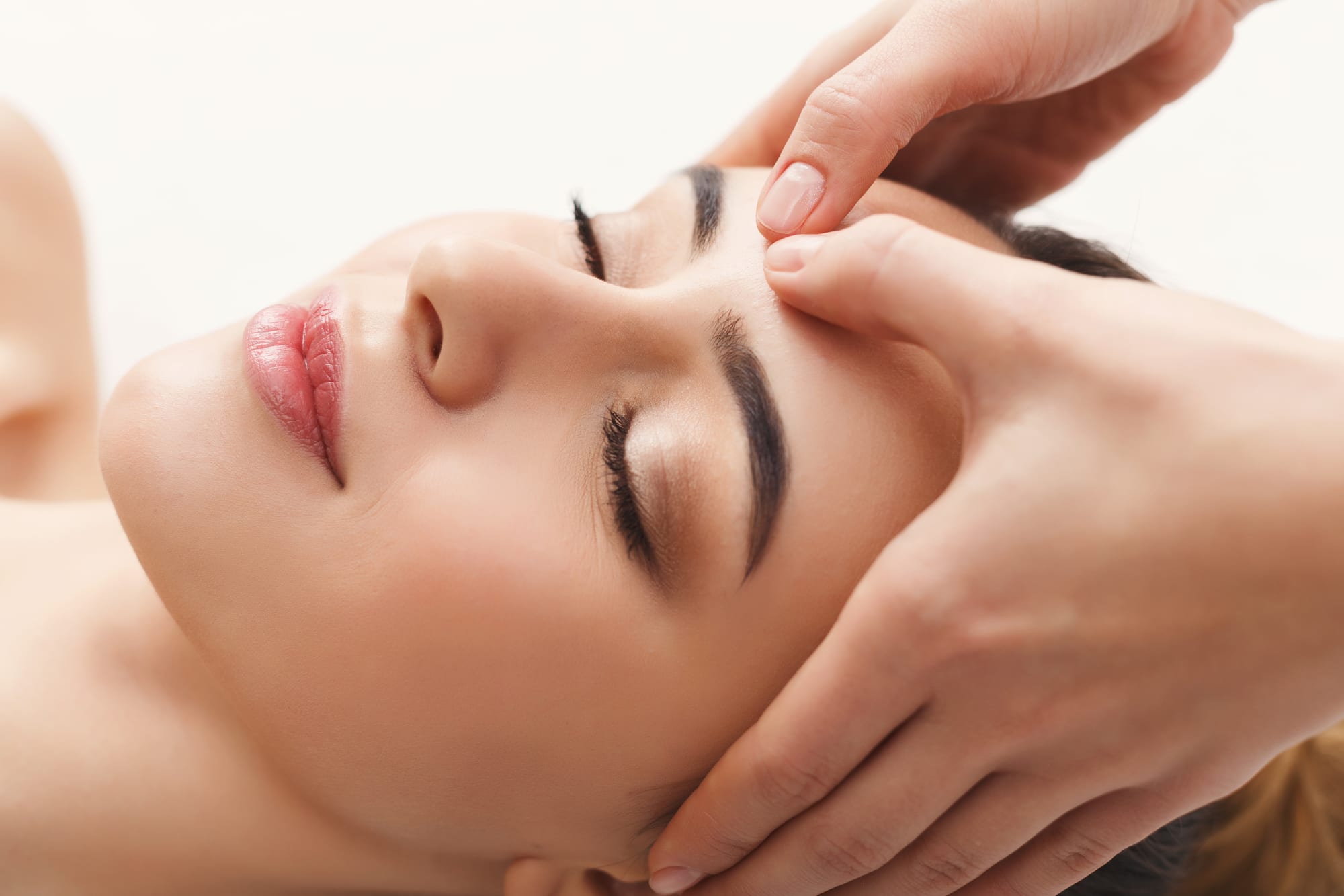 Woman getting professional facial massage at spa