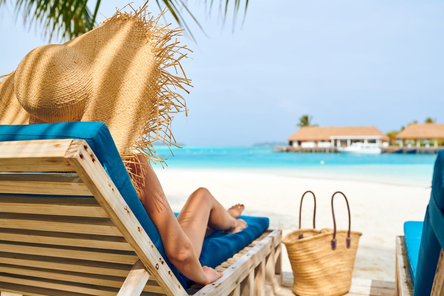 Woman at beach on wooden sun bed loungers