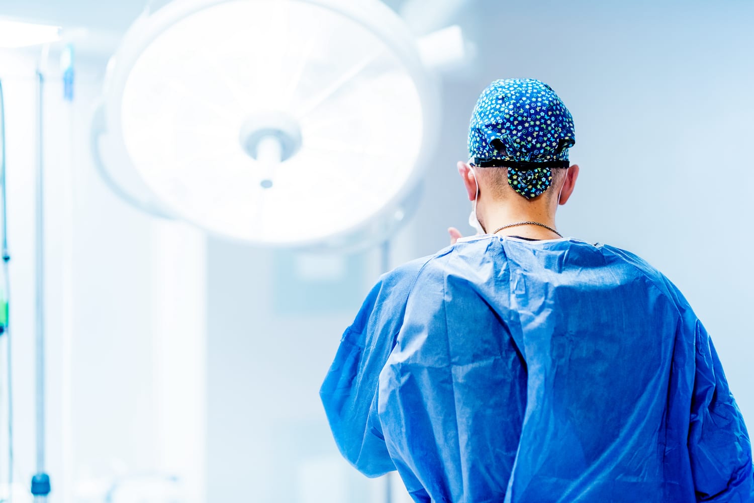 male surgeon in scrubs in the operating room preparing to operate