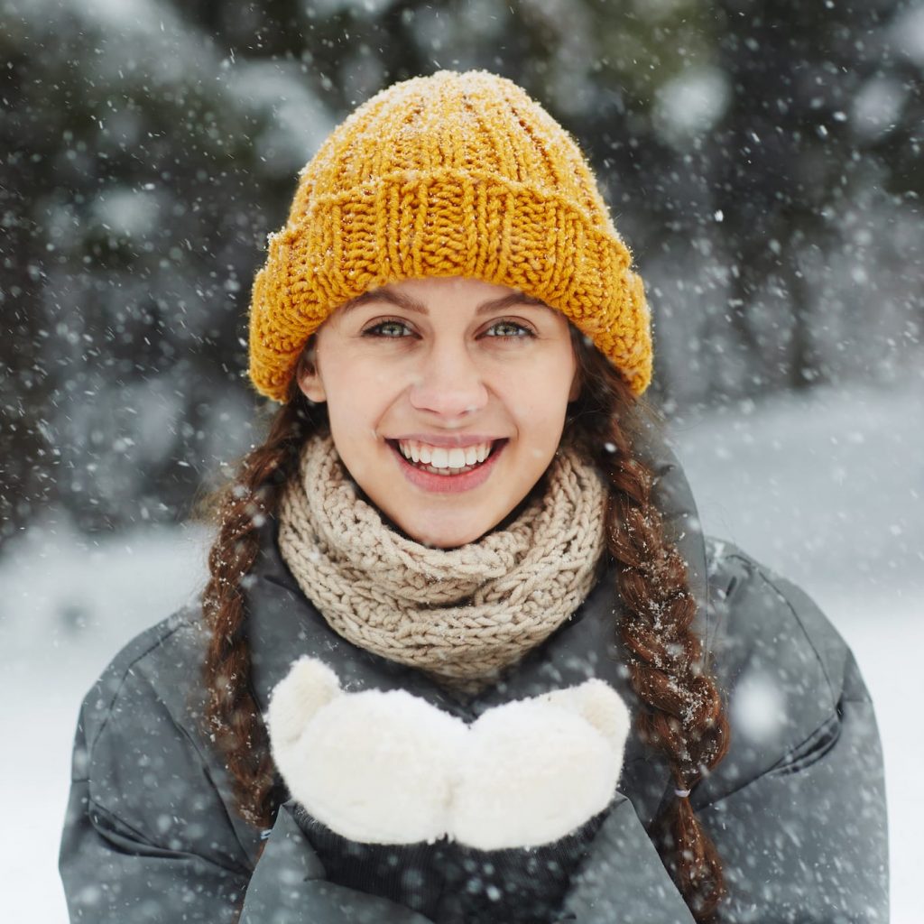 smiling young woman standing in the snow