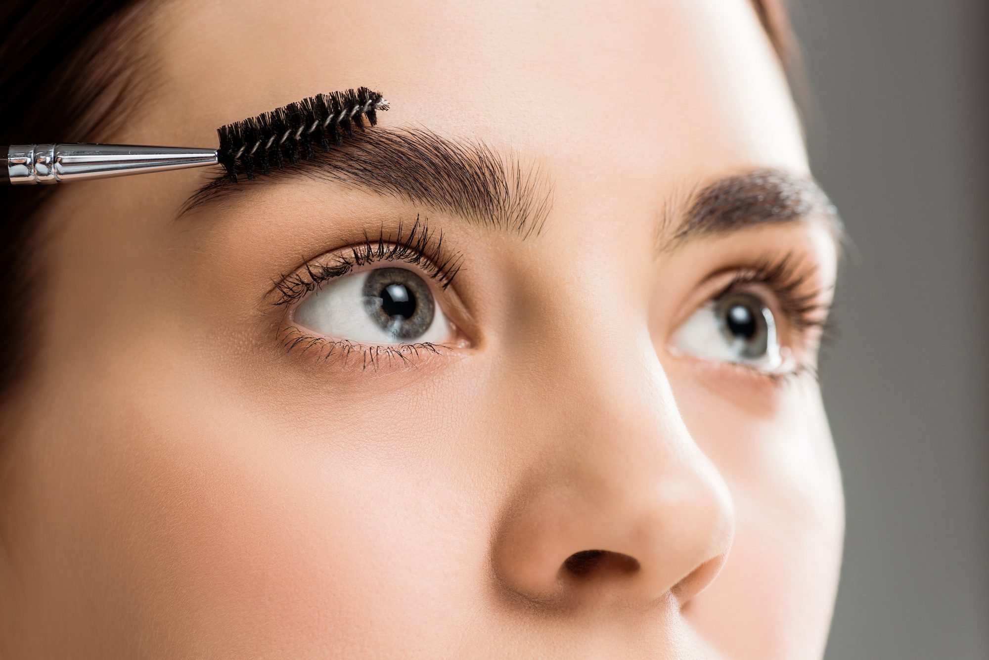 woman putting on eyebrow makeup