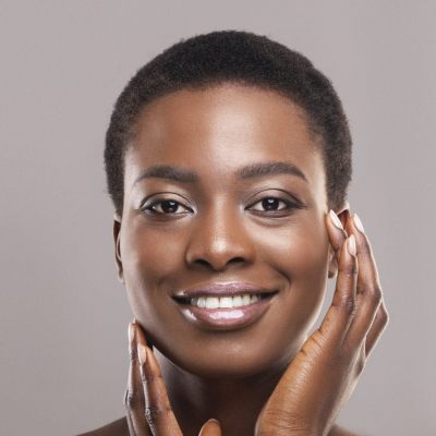 Beautiful black woman with short hair touching her smooth cheeks Beautiful young woman holding her face